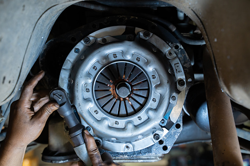 auto mechanic in garage,service clutch system.